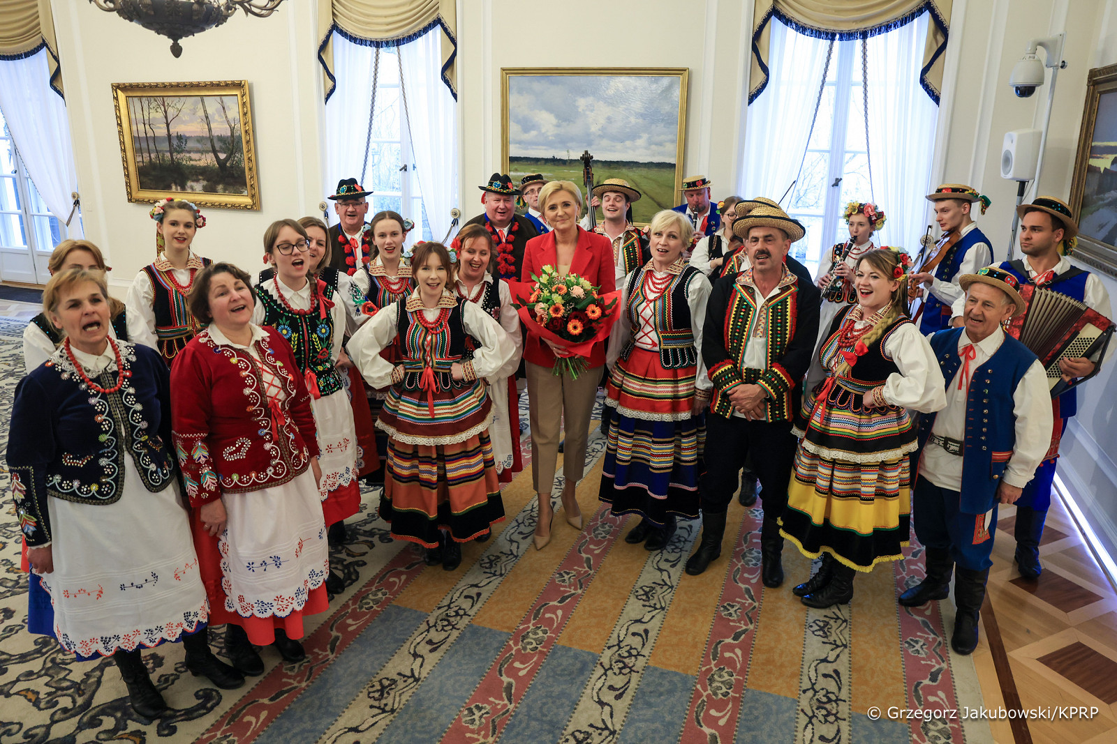 zdjęcie przedstawia członk&oacute;w zespołu pieśni i&nbsp;tańca Wolany w&nbsp;ludowych strojach z&nbsp;Pierwszą Damą Agatą Kornhauser&ndash;Dudą w&nbsp;Belwederze