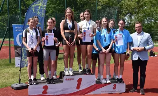 zdjęcie na podium sztafet dziewcząt które zajęły miejsca od I-III - Wola Zarczycka, Nowa Sarzyna i Ruda Łańcucka z boku podium sekretarz miasta i gminy nowa sarzyna Adam Madej
