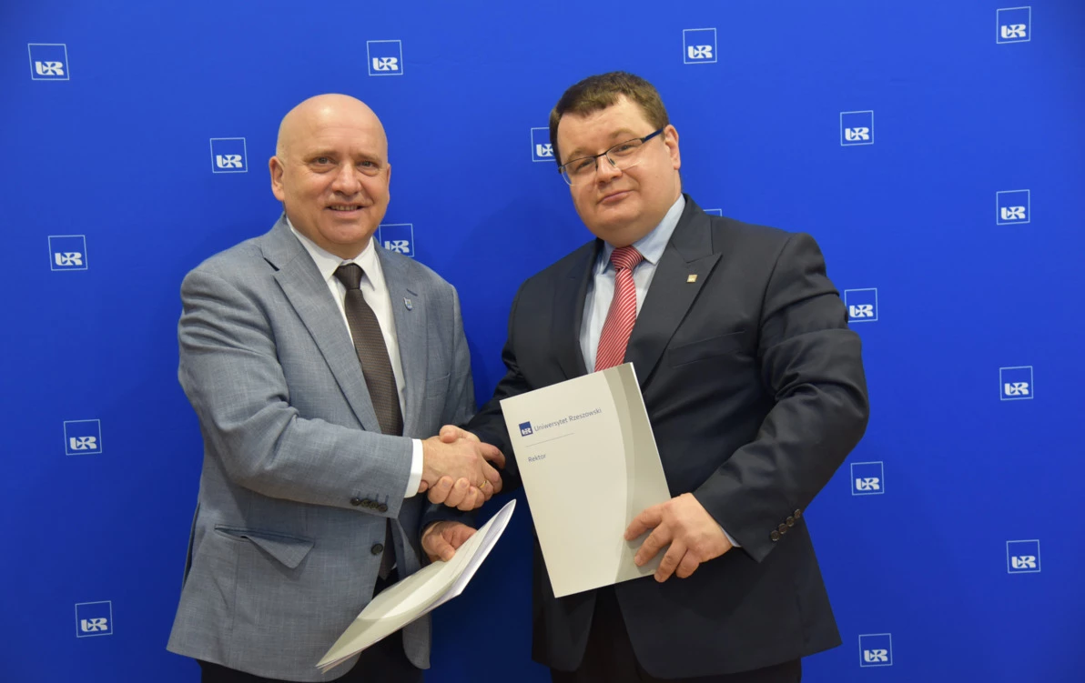 zdjęcie przedstawia burmistrza nowej sarzyny Andrzeja Rychla podającego dłoń rektorowi Uniwersytetu Rzeszowskiego prof. dr hab. n. med. Adamowi Reichemowi.